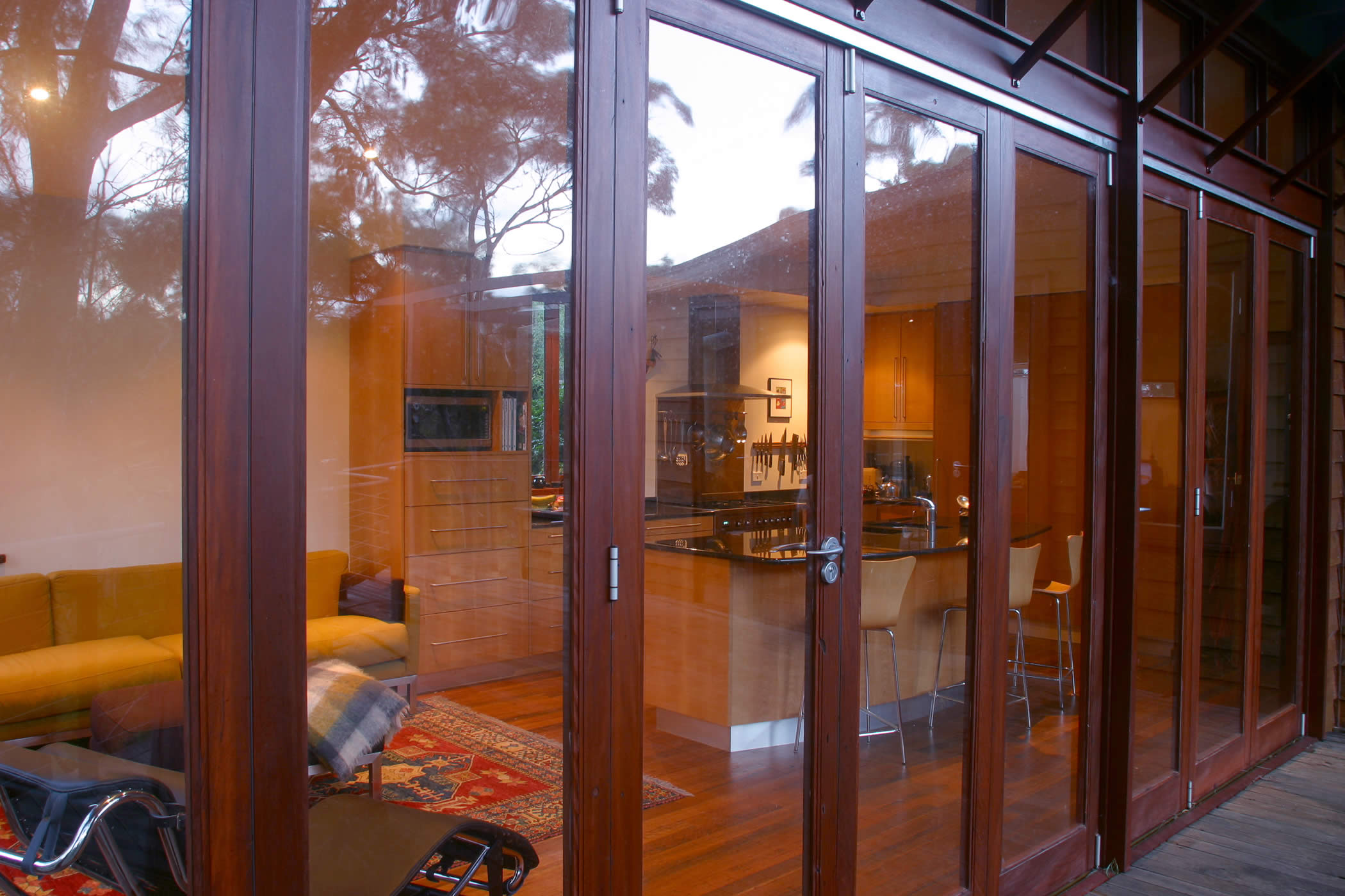 House Butler Extension: Detail of glazed recycled hardwood timber bi-fold doors (mixed eucalyptus) with view to interior recycled hardwood flooring. Photo by Peter Whyte.