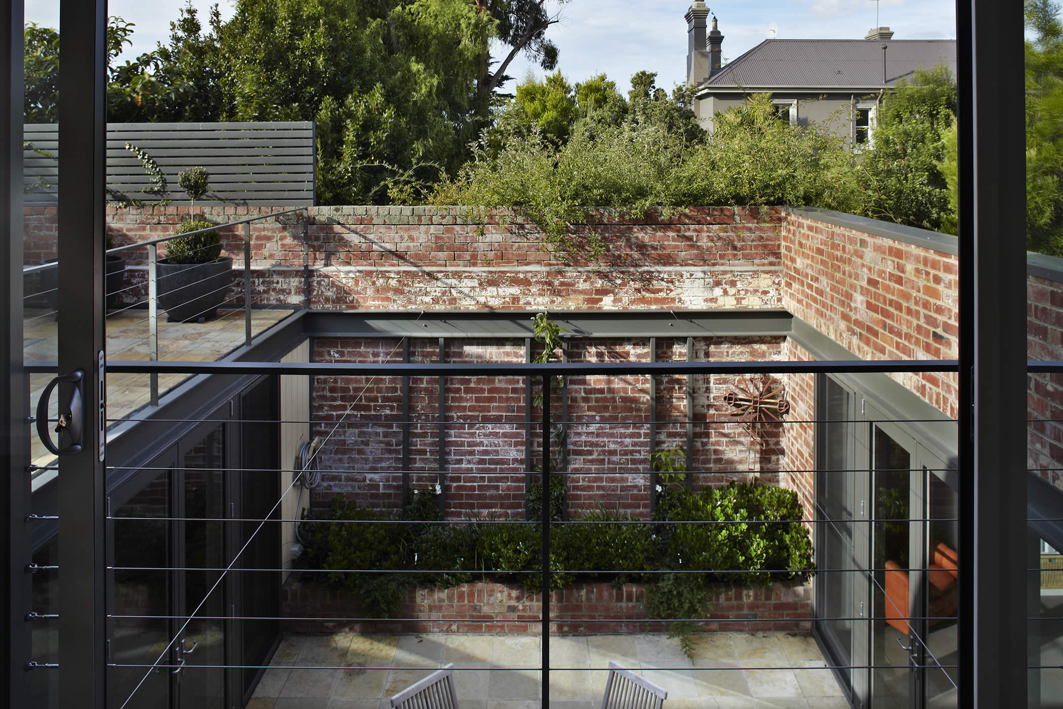 93a Hill Street, West Hobart, Tasmania:  A rear room and unusable yard turned “inside – out” forms a central external courtyard, introducing sunlight, warmth, spaciousness and borrowed views over treetops, gardens and roofscapes. Photo by Peter Whyte.