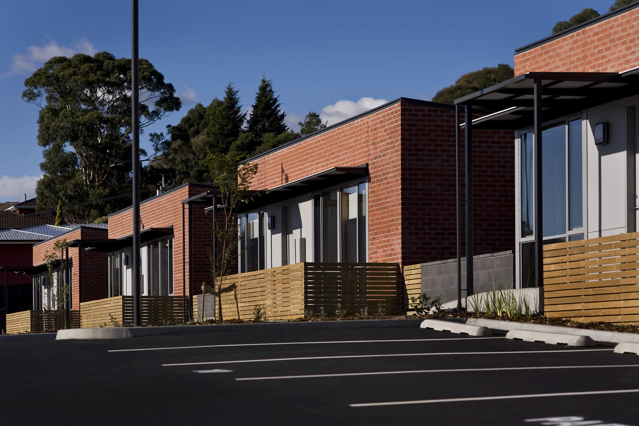 Balamara Street Housing, Bellerive, Tasmania: A communal courtyard is devoted to vehicular access, parking and pedestrian movement with easy ramped universal access to all the dwellings. Photo by Ray Joyce.