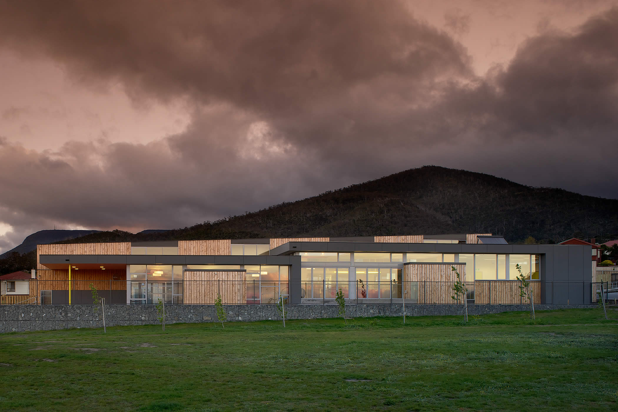 Chigwell Child and Family Centre, Tasmania: External vertical macrocarpa timber cladding alternates with double glazed windows and doors which capture northern daylight and borrowed views extending over the adjacent park.  Photo by Ray Joyce.