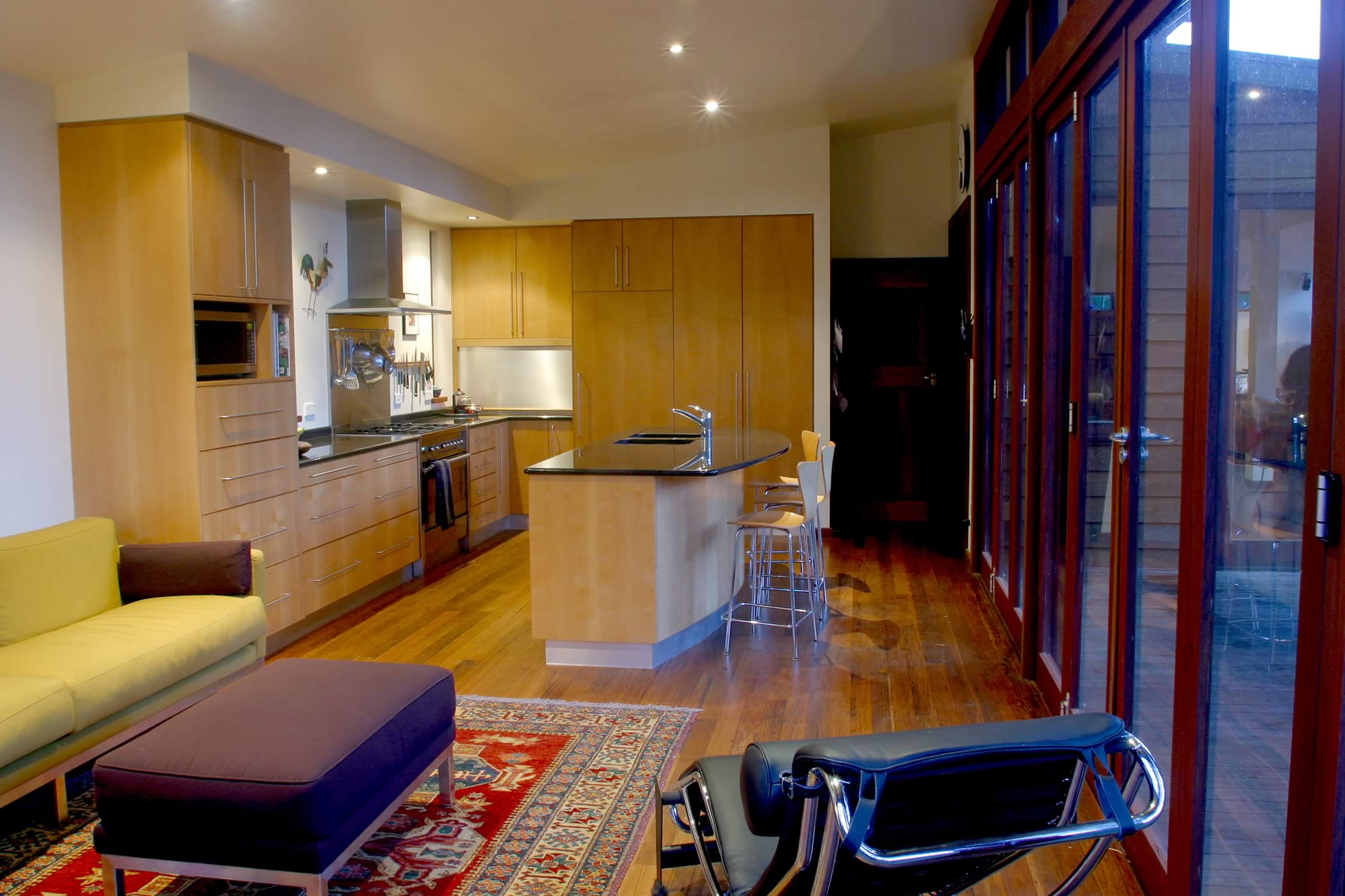 House Butler Extension: Interior recycled hardwood flooring with glazed recycled hardwood timber bi-fold doors (mixed eucalyptus) to exterior deck. Photo by Peter Whyte.