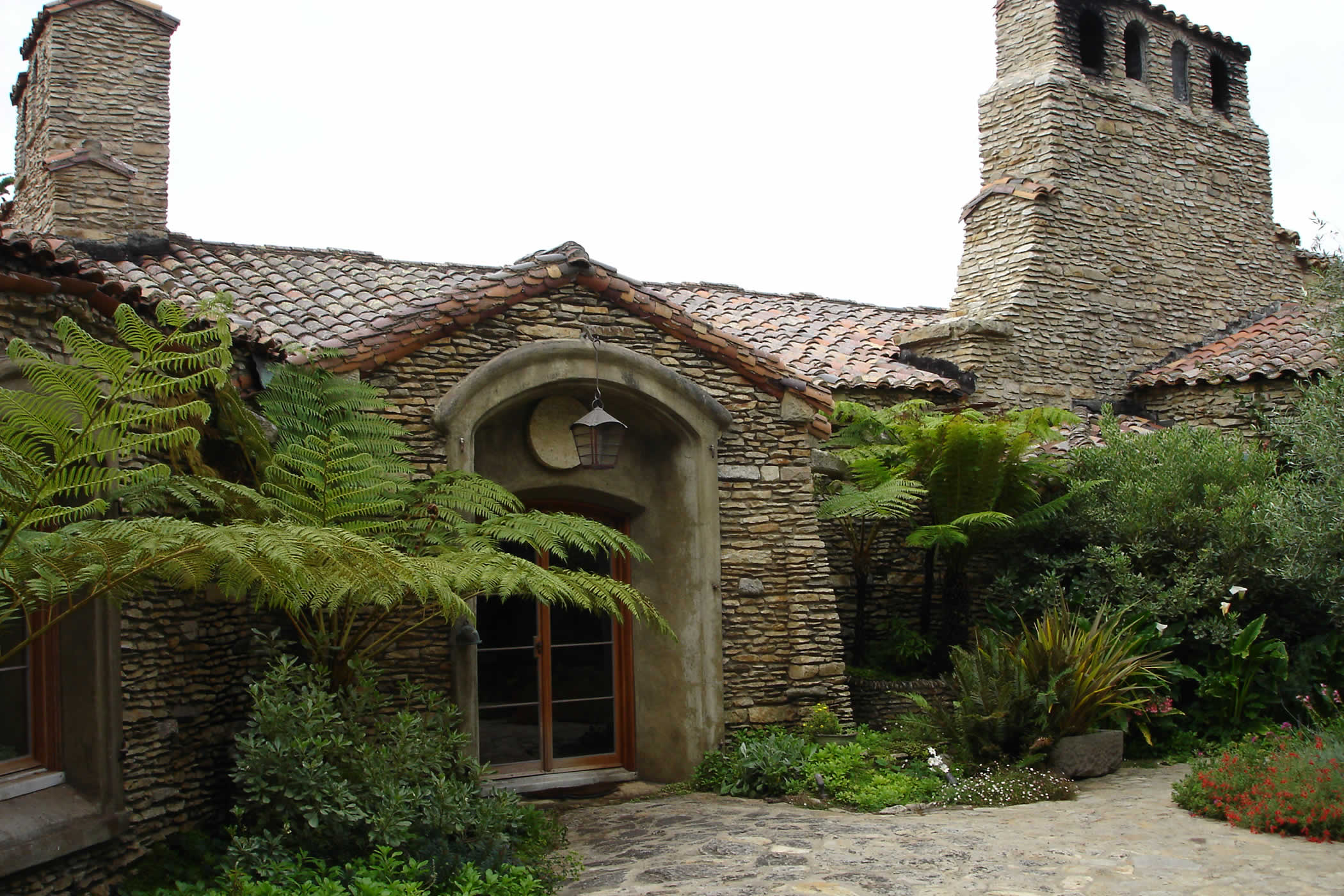 James House Lantern Fitting, Carmel Highlands, California: A handmade copper entrance lantern fitting, designed by Morrison & Breytenbach Architects, lights the historic James House arrival courtyard by Charles Greene.