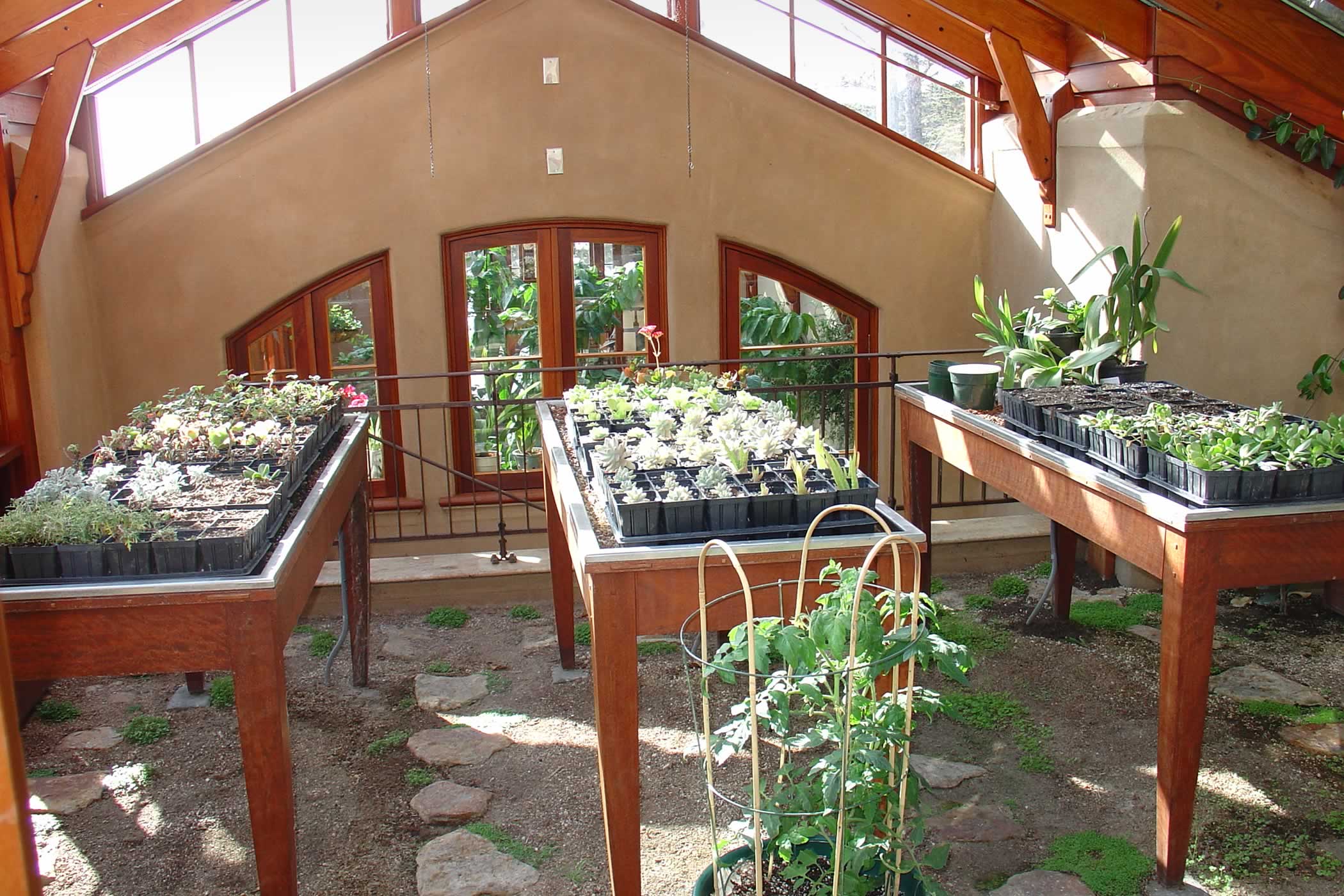 The James House Greenhouse, Carmel Highlands, California: A recycled eucalyptus hardwood timber roof structure, window frames and seedling propagation tables combine with an earth floor and stone flags in the propagation room.