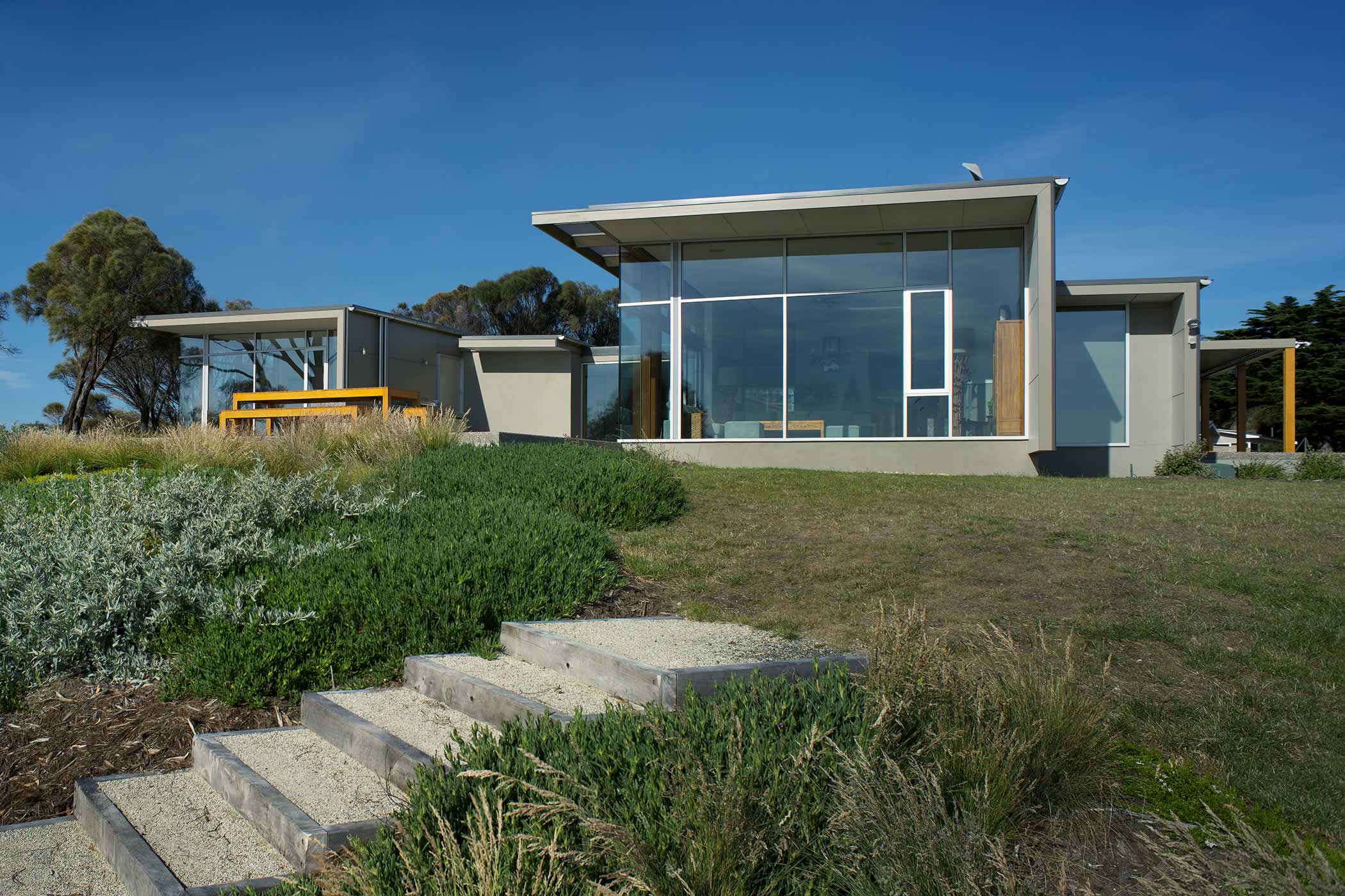 Johns Point residence, South Arm, Tasmania: The enclosing building envelope shields from icy southerlies opening to northern warmth for thermal comfort while easy access to beach, sea and coastal walks gives access to the elements. Photo by Ray Joyce.