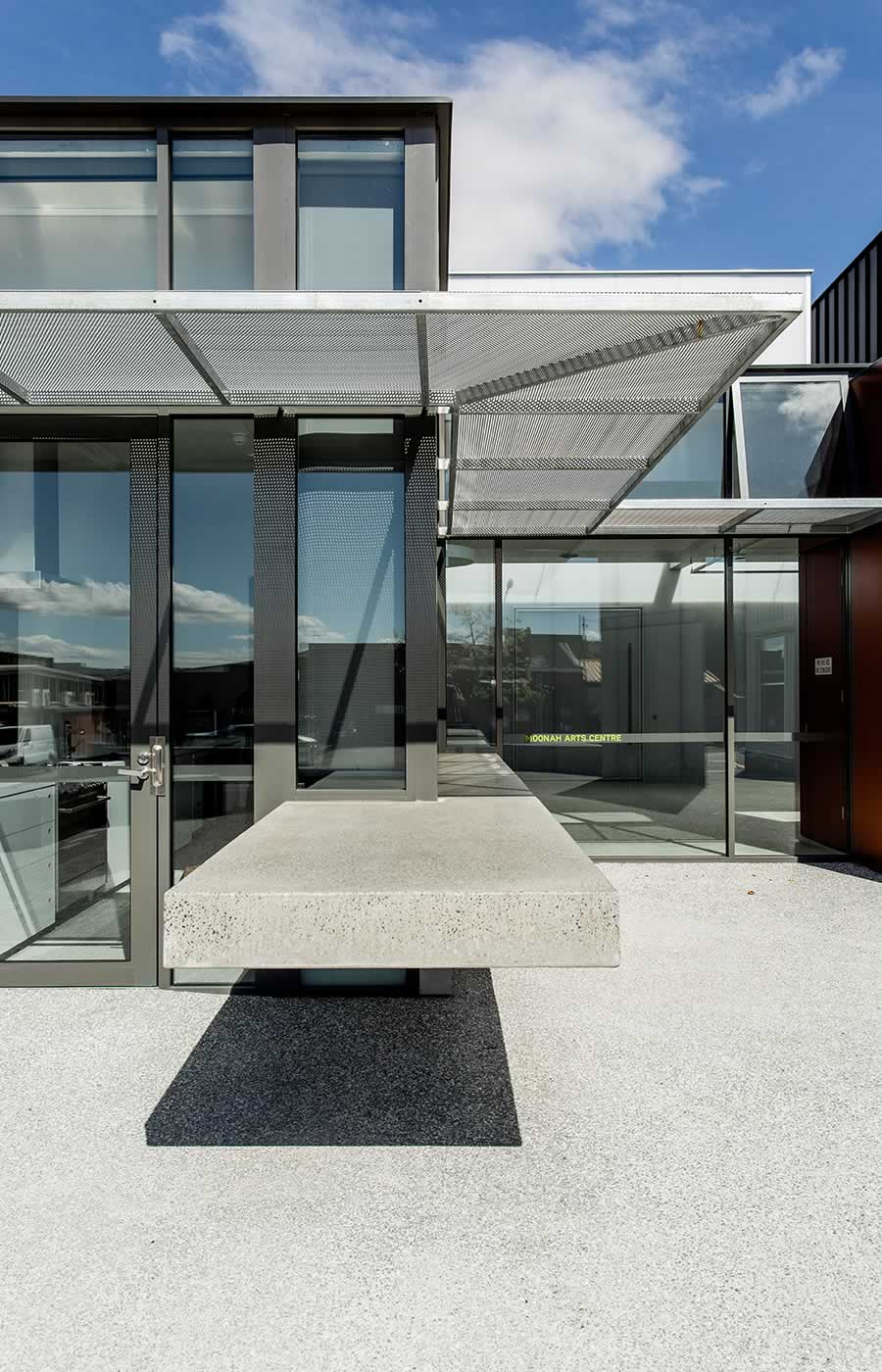 Moonah Arts Centre Kitchen, Tasmania: Anticipating flexible and varied use over time, a cantilevered polished concrete cafe counter flows from the interior to exterior transforming from indoor servery to outdoor island bench. Photo by Adam Gibson.