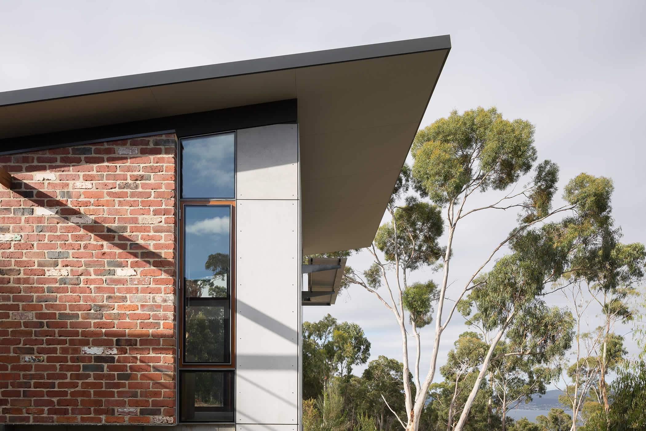 Sandy Bay, Tasmania: Beautiful, resilient, no and low-maintenance recycled bricks and hard wood timber window frames with compressed sheet panels address bush fire attack level (BAL) requirements of the site.  Photo by Thomas Ryan.