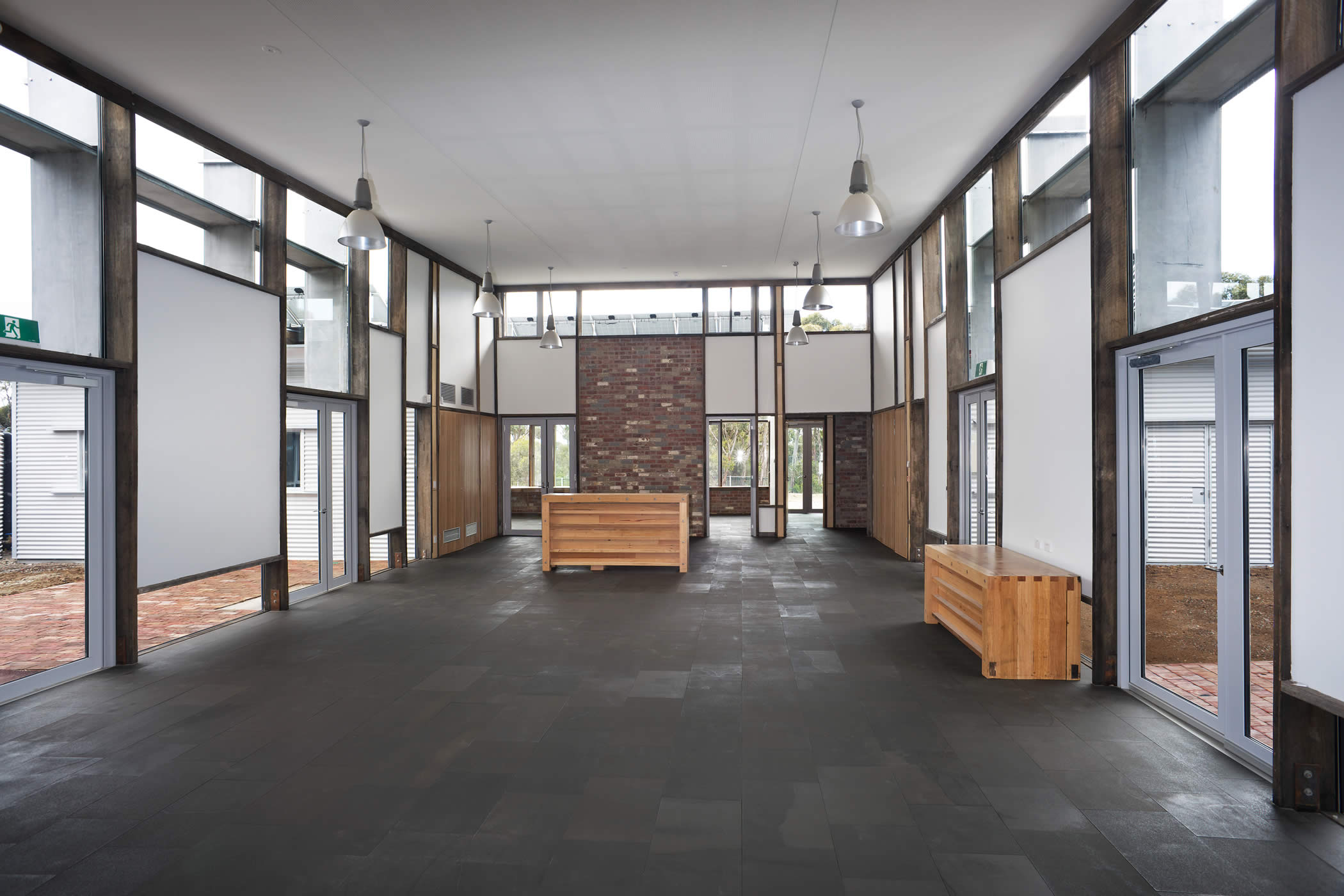 Sustainability Learning Centre, Mount Nelson, Tasmania: The imposing entrance foyer with recycled structural timber, recycled brick panels and basalt flag flooring on an earth substrate, is suitable for functions and exhibitions. Photo by Ray Joyce.