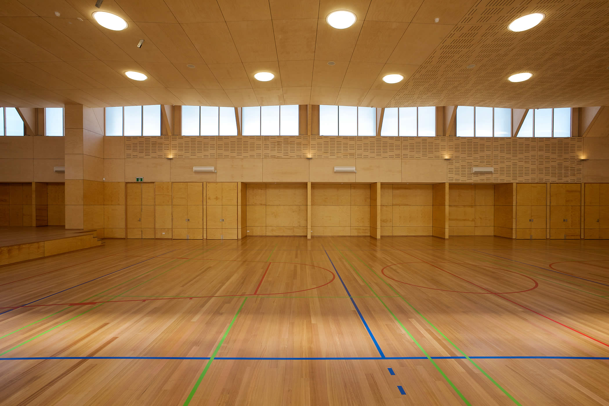 Tarremah School Hall, Kingston, Tasmania: The acoustically engineered ceiling is a subtle sculptural element, acoustic panel perforations a decorative pattern, and plywood lining meets client requirements for natural materials.  Photo by Ray Joyce.