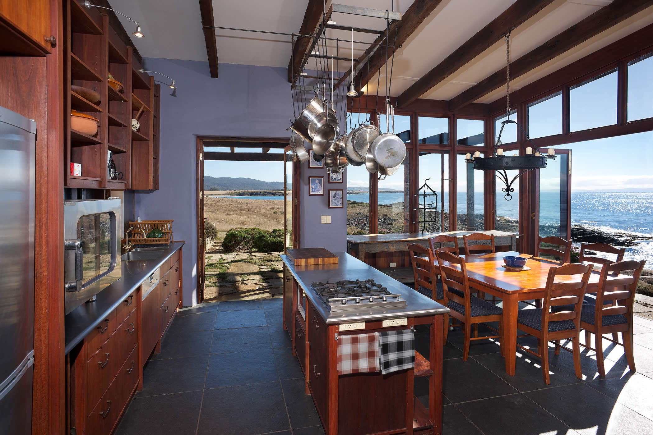 Thalia Haven, East Coast Tasmania: The passive solar jarrah kitchen and dining area opens to spectacular land- and seascapes through recycled hardwood windows and bi-fold doors. Photo by Ray Joyce.