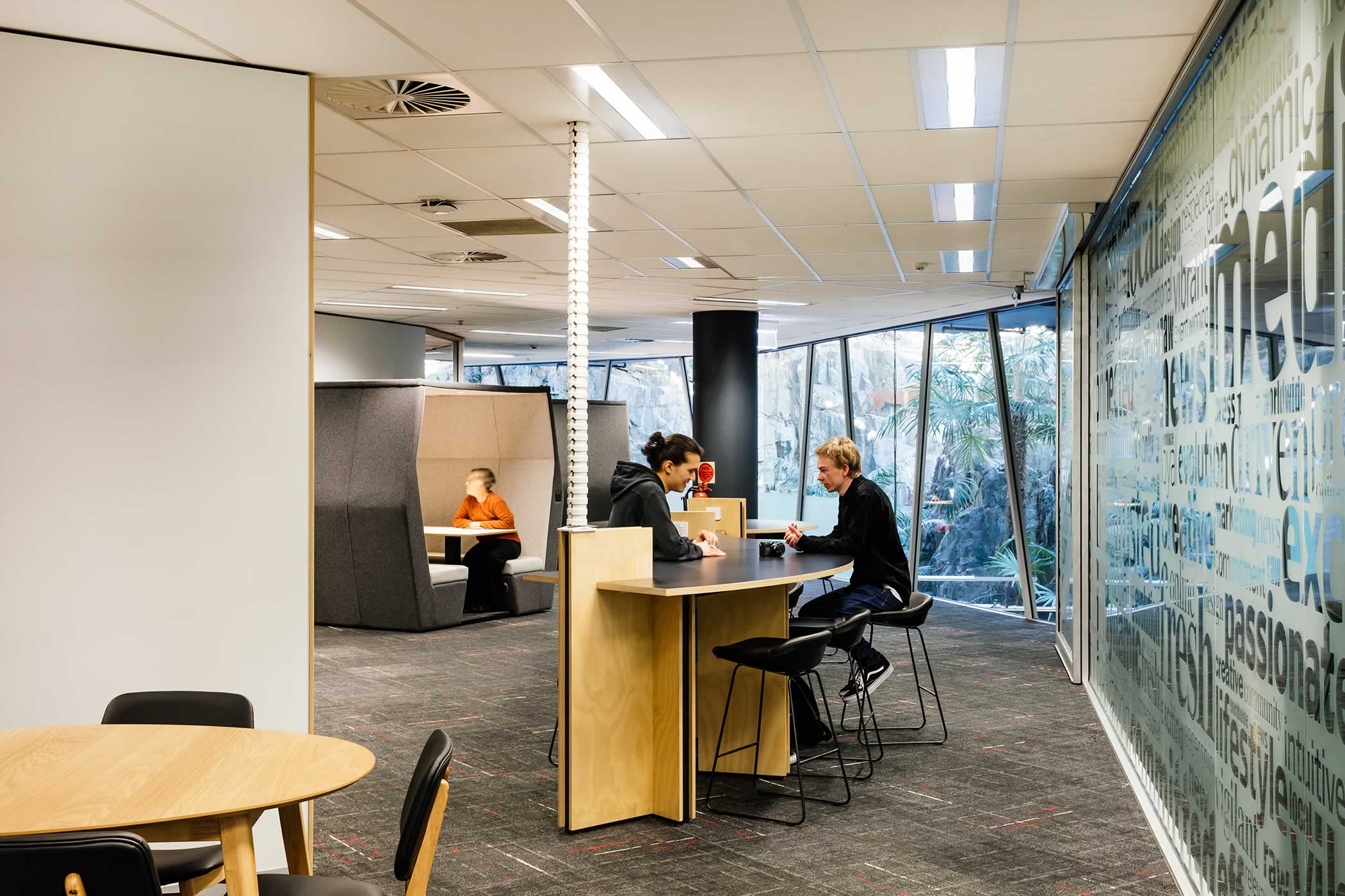 The Media School – University of Tasmania: Enclosures are positioned away from existing glazed edges bringing borrowed quarry views and natural light to shared informal study, kitchenette and social space. Photo by Adam Gibson.