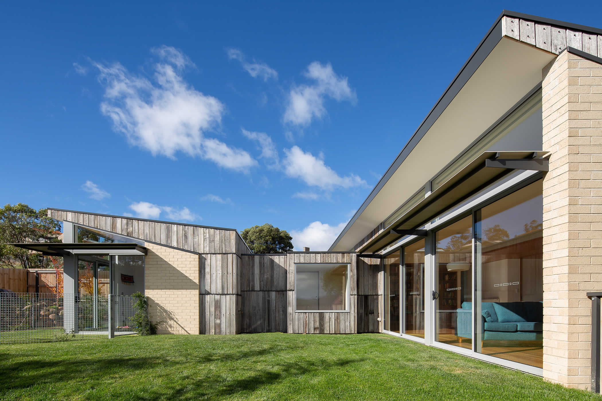 Tiger House, Lindesfarne, Tasmania: The open plan kitchen, dining and lounge opens to a sunny garden. An arrival courtyard separates it from the master suite and meditation room to create a separate place of intimacy and retreat. Photo by Thomas Ryan.