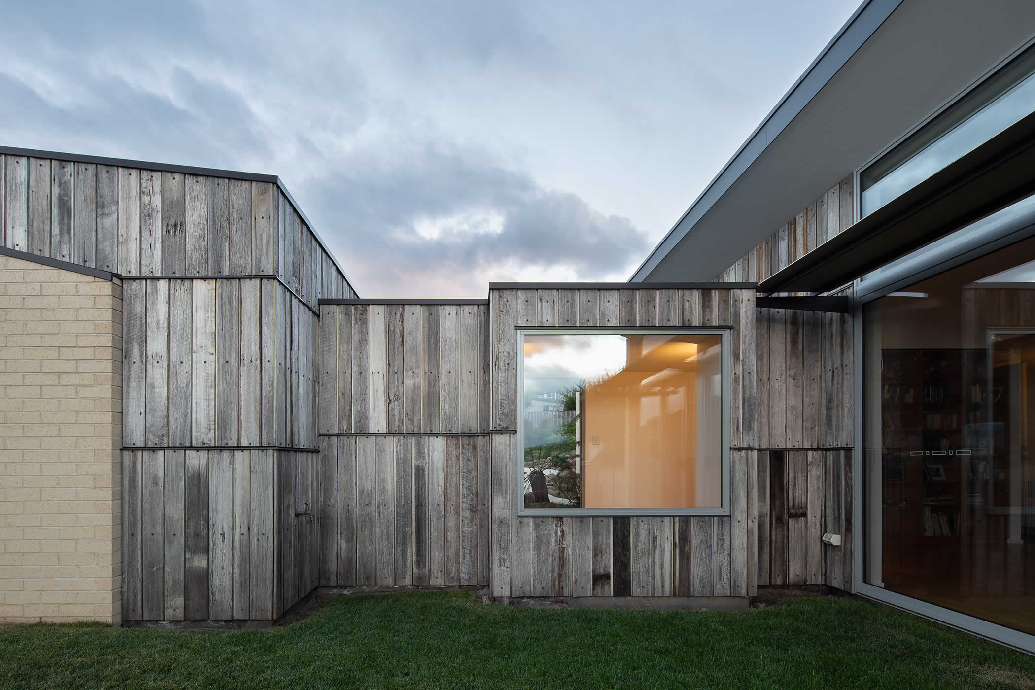 Tiger House, Lindesfarne, Tasmania: The theme of separate, expressed forms and recycled scrap Tas Oak fence paling cladding contrasting with brickwork repeats around the building to create an distinctive architectural language. Photo by Thomas Ryan.