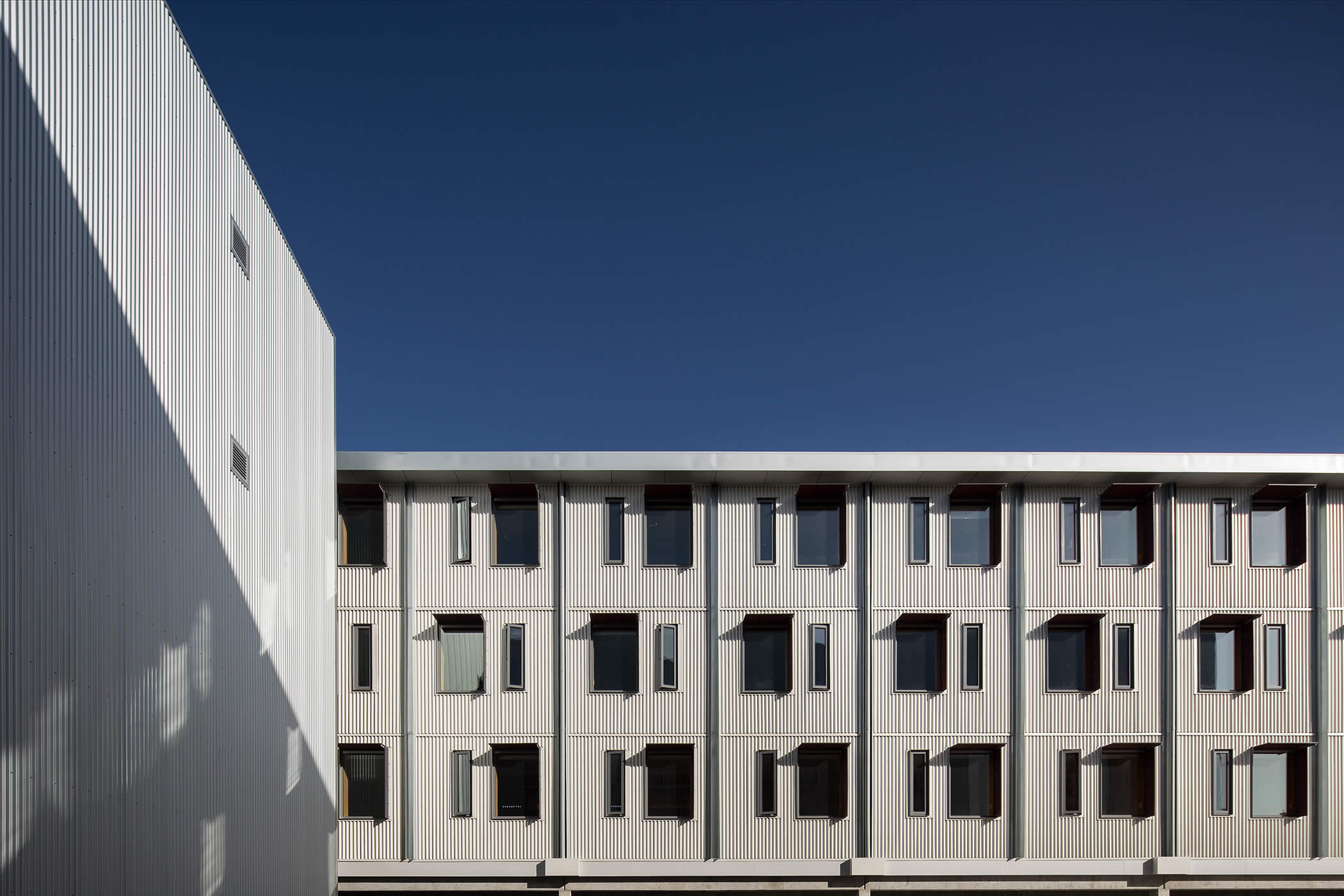 UTAS Inveresk Student Residences, Tasmania: The northern facades integrated sunshades and trickle feed ventilation and pay homage to the Inveresk heritage context and nearby corrugated iron of industrial rail sheds of the past. Photo by Thomas Ryan.