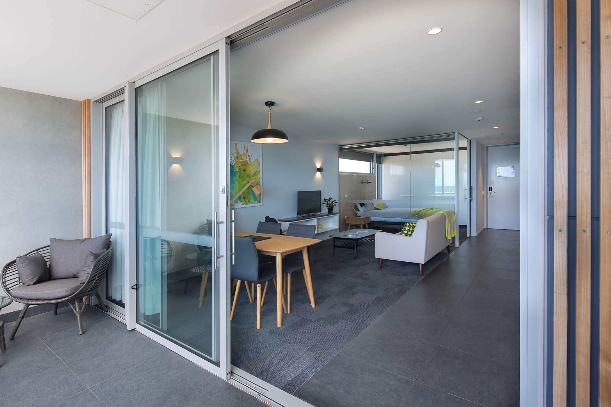 UTAS West Park Lecturer Apartments, Tasmania: The contemporary interior with glazed bedroom partition and open plan living extends onto a BBQ patio overlooking Burnie Beach and bringing in light and warmth. Photo by Thomas Ryan.